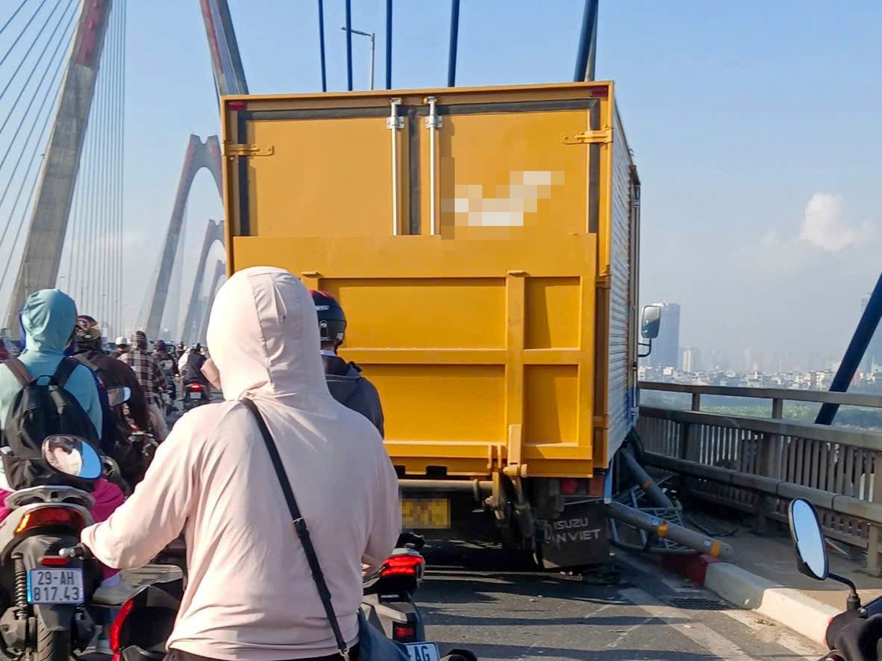 Chiếc xe thùng màu vàng lao qua dải phân cách trên cầu Nhật Tân, đâm vào thành cầu