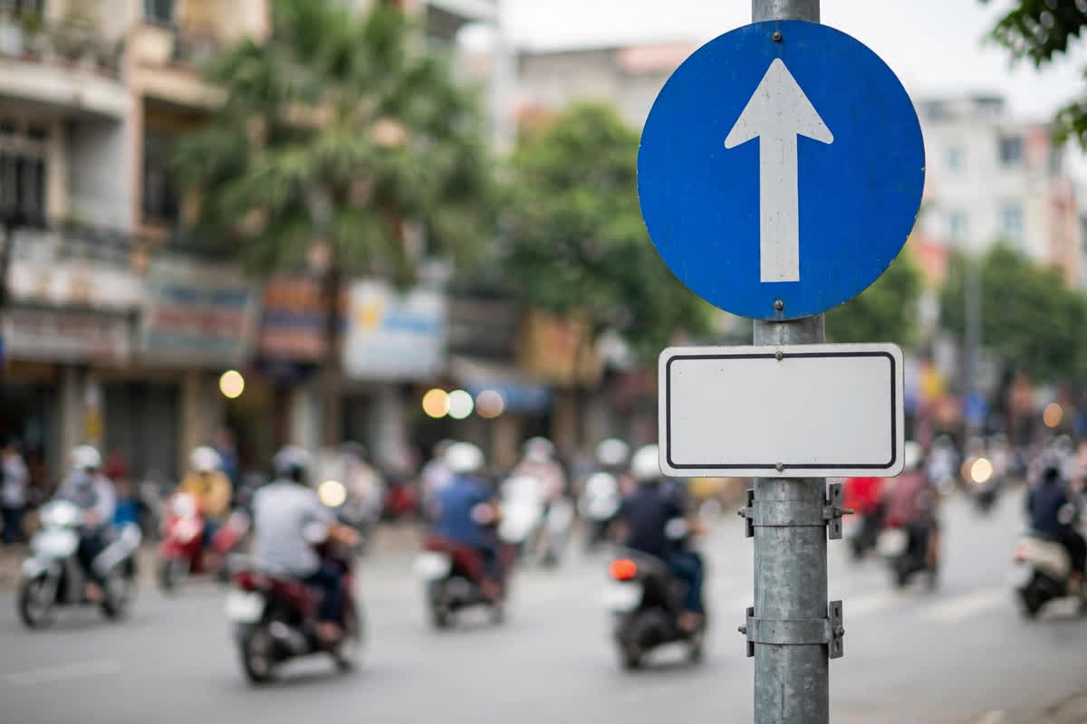 Minh họa: Biển báo hiệu lệnh đi thẳng phía trên và tấm biển phụ hình chữ nhật trắng phía dưới trên đường phố Việt Nam